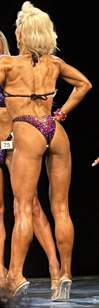 zawodniczka bikini fitness na scenie w pozycji back pose